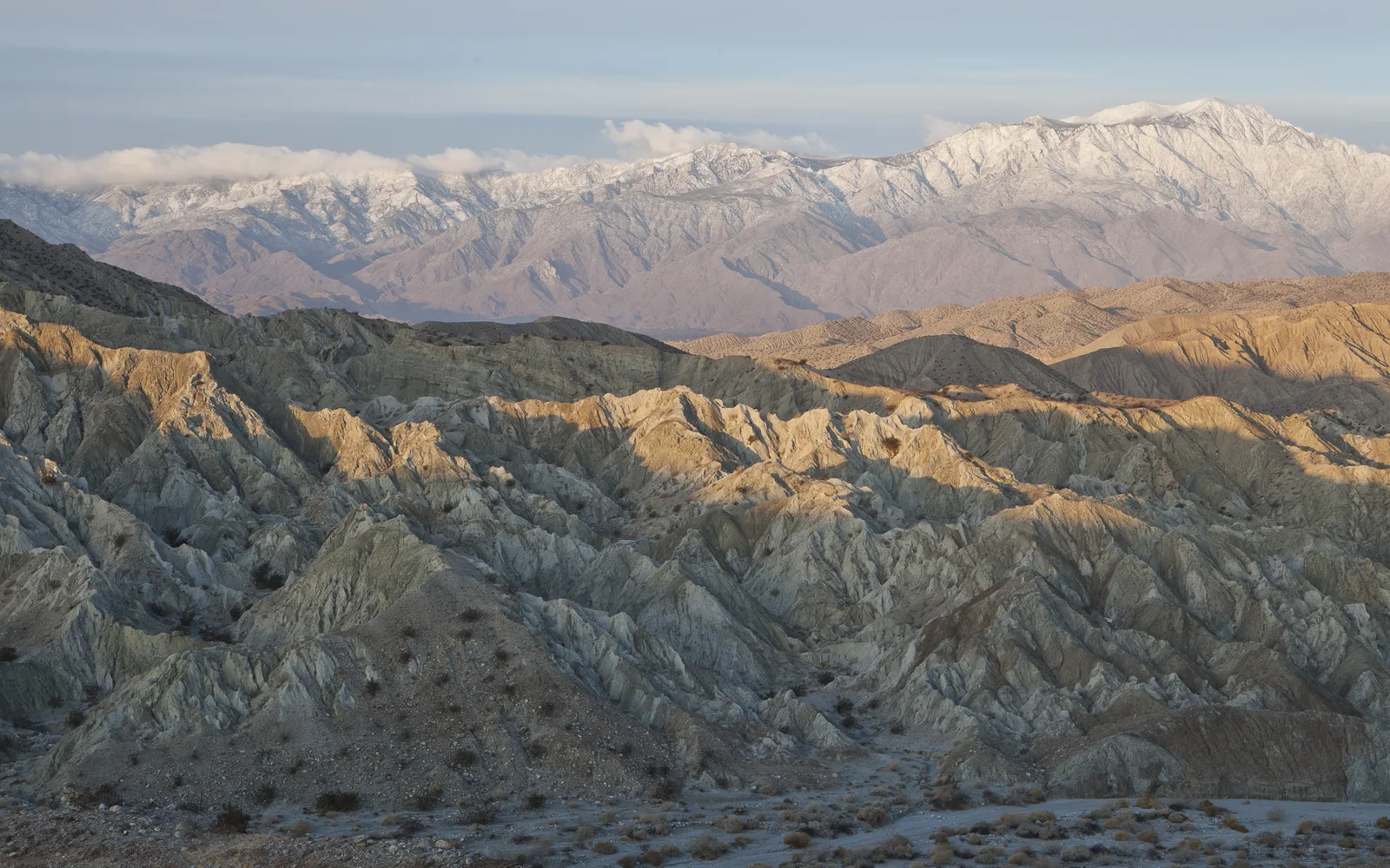 Rugged desert mountains rising from the valley floor under a blue sky